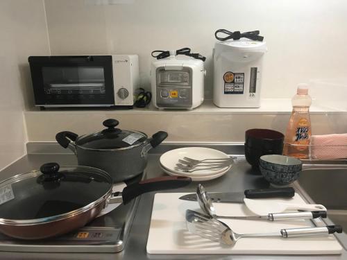 宜野湾市宜野湾每周港口景公寓的厨房柜台配有带餐具的炉灶