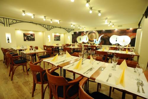 埃格尔Hotel Minaret&Étterem的餐厅设有木桌和黄餐巾