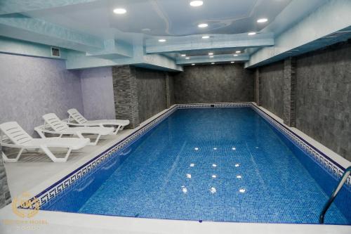 巴库GM City Hotel的一个带桌椅的大型游泳池
