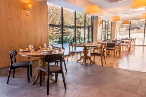 AvdancıkAbant Lotus Otel的用餐室设有桌椅和窗户。