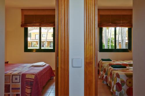 帕尔斯卡萨斯高尔夫休闲旅馆的带2扇窗户的客房内的2张床