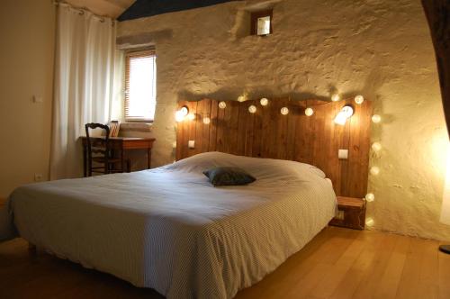圣锡尔克－拉波皮Chambre d'hôte et gîte de Cantagrel的一间卧室配有一张大床和灯光