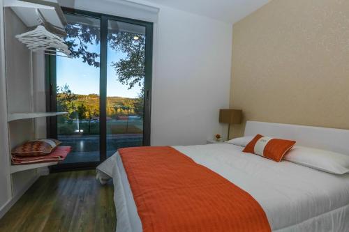 博蒂卡什Boticas Parque Natur Houses的一间卧室设有一张床和一个大窗户