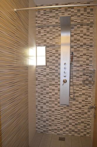 卡托克拉克阿纳APARTMENT V.M.的浴室设有瓷砖墙和淋浴间。