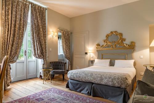 贝桑松Hôtel Restaurant Spa Le Sauvage的配有一张床和一把椅子的酒店客房