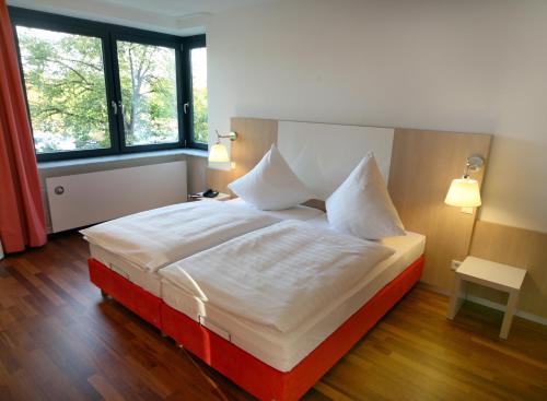 埃尔弗斯豪森乌尔里希酒店的卧室配有一张带白色床单和枕头的大床。