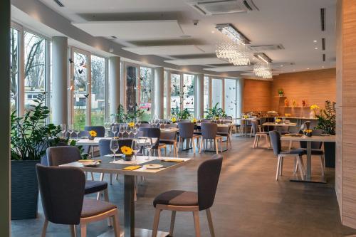 波兹南维瓦尔第酒店的用餐室设有桌椅和窗户。