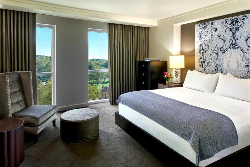 堪萨斯城The Fontaine的卧室配有床、椅子和窗户。