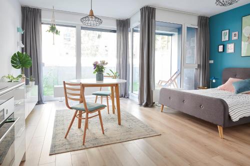 波兹南Mint Apartment的一间带桌子和床的卧室以及一间带蓝色墙壁的卧室
