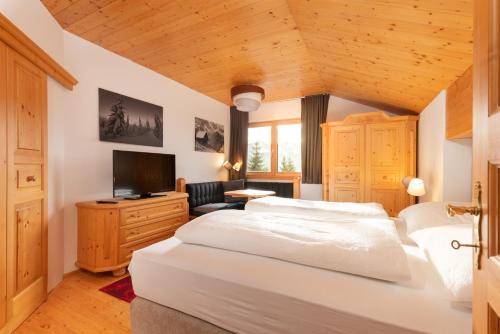 瓦格赖恩Designferienhaus Luxus Bergchalet XXL Ski In-Out Snow Space Wagrain Flachau的卧室配有一张白色大床和电视。