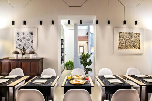 那不勒斯Artemisia Domus - Centro Storico的用餐室配有黑桌和白色椅子