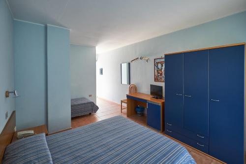 伊索拉迪卡波里祖托罗亚斯度假村的蓝色卧室配有一张床和一张书桌