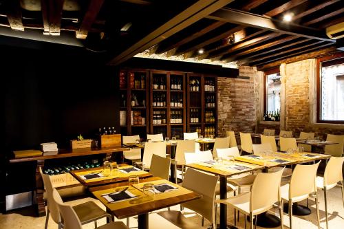 威尼斯小提埃波罗旅馆的用餐室配有木桌和白色椅子