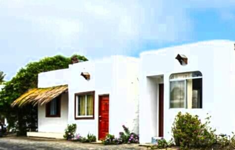 比亚米尔港Hospedaje Sarita的一间白色的小房子,有红色的门