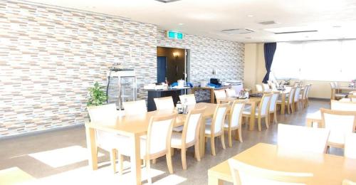 静冈Seagrande Shimizu Station Hotel / Vacation STAY 8211的餐厅设有木桌和椅子,拥有砖墙