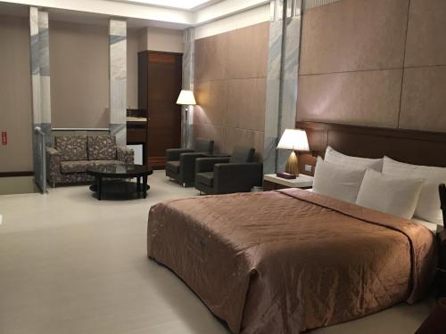 台南京华商务汽车旅馆的酒店客房设有床和客厅。