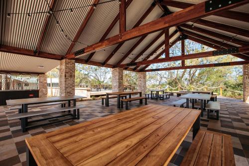 邦加里BIG4 Sandstone Point Holiday Resort Bribie Island的一个带木桌和长凳的大型凉亭