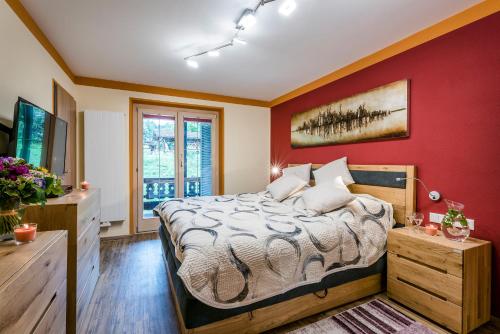 贝希特斯加登阿尔彭格卢欣假日天堂酒店的一间卧室设有一张床和红色的墙壁