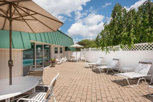波特兰波特兰华美达酒店的庭院配有桌椅和遮阳伞。