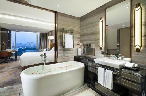 上海上海千禧海鸥大酒店的带浴缸、水槽和床的浴室