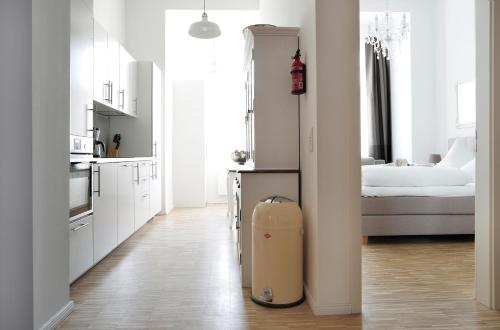 柏林SC 2 Cozy Family & Business Flair welcomes you - Rockchair Apartments的一间白色的厨房,房间中间有一只手提箱