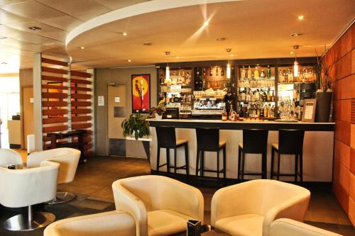 加龙河畔波泰Hotel L'Hotan的餐厅内的酒吧配有椅子和柜台