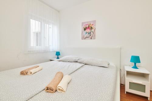 乌马格尼娜公寓的白色卧室,配有带毛巾的床