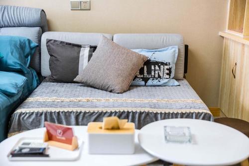 洛阳河南省洛阳市·南湖音乐喷泉广场·路客精品公寓·00153160的客房配有带枕头和桌子的床。