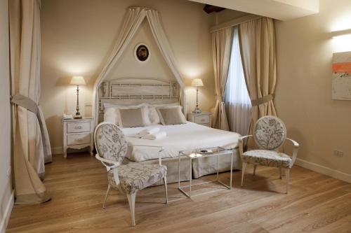 阿斯科利皮切诺100多丽住宅酒店的卧室配有白色的床和2把椅子