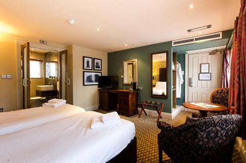 卡迪夫玛茨特斯酒店的酒店客房,配有两张床和椅子