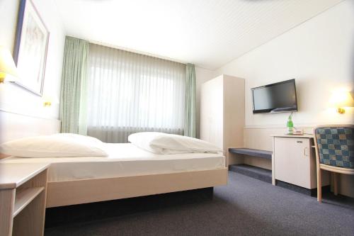 卡尔斯特米歇尔斯加尼兰德豪斯酒店的一间酒店客房,配有一张床和一台电视