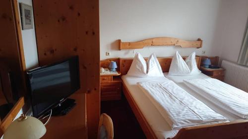 TauplitzalmHotel Alpenrose的一间卧室配有两张床和一台平面电视