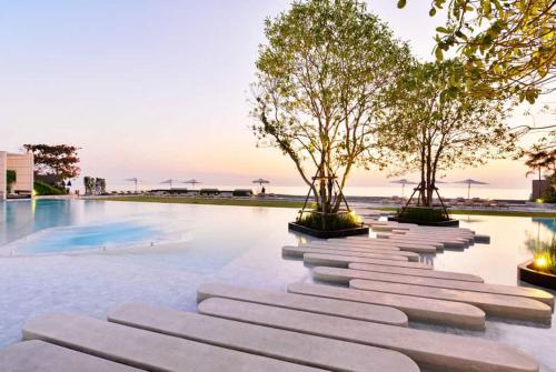 纳仲天Veranda Residence Pattaya x Sea & Sky View的游泳池旁的一排树木