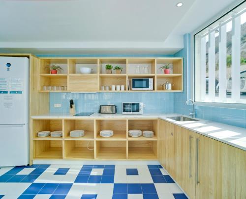 卡塔赫纳LoopINN Hostel Cartagena的厨房设有木制橱柜和蓝色瓷砖地板。