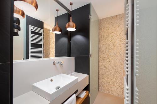 Resnik罗格拉酒店的浴室设有白色水槽和镜子
