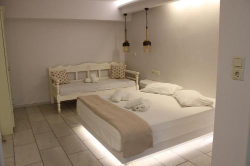 纳克索乔拉瓦西利科斯公寓式酒店的白色客房的两张床,配有灯