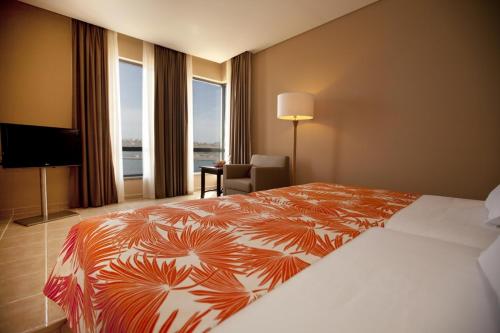 普拉亚Pestana Tropico Ocean & City Hotel的酒店客房设有一张床和一个大窗户