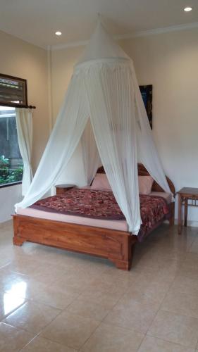 乌布阿尔加纳稻田简易别墅酒店的一张带天蓬的床