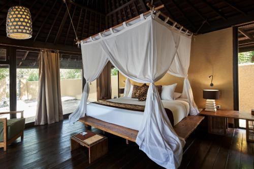 班尤温当孟赞干奴萨湾度假酒店的一间卧室配有一张带蚊帐的床