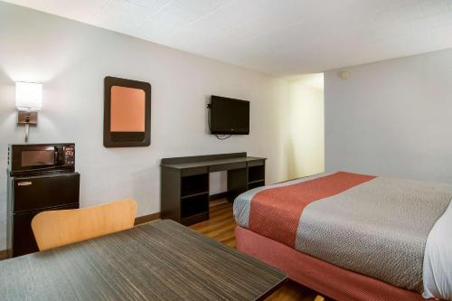 新斯坦顿新斯坦顿6号汽车旅馆的酒店客房设有两张床、一张桌子和电视。