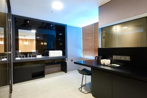 釜山Hotel tt Seomyeon的浴室配有盥洗盆和带镜子的梳妆台