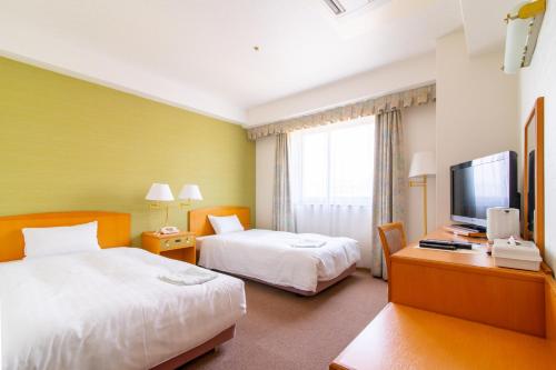 高知光明公园酒店的酒店客房设有两张床和电视。