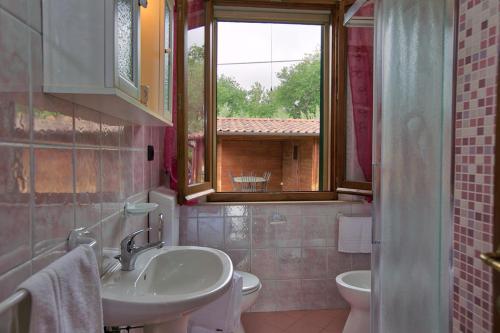 特拉西梅诺湖畔托罗索尼韦利亚度假屋的一间带水槽和卫生间的浴室以及窗户。
