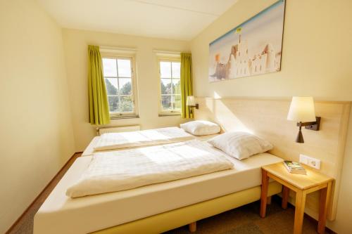 奥德多普Center Parcs Port Zélande beach的一张大白色的床,位于带桌子的房间