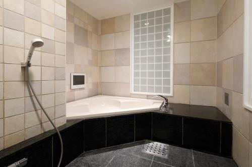 Togo情人多哥酒店（仅限成人）的带浴缸的浴室和窗户