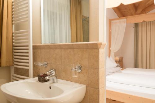 圣维吉利奥奥林匹亚酒店的一间带水槽和一张双层床的浴室