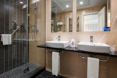 马德里格兰维尔塞斯酒店的一间带两个盥洗盆和淋浴的浴室