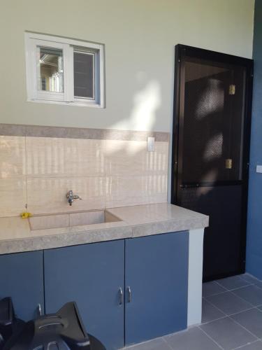 碧瑶Restful 3BR Hillside Duplex House的厨房配有水槽和黑冰箱。