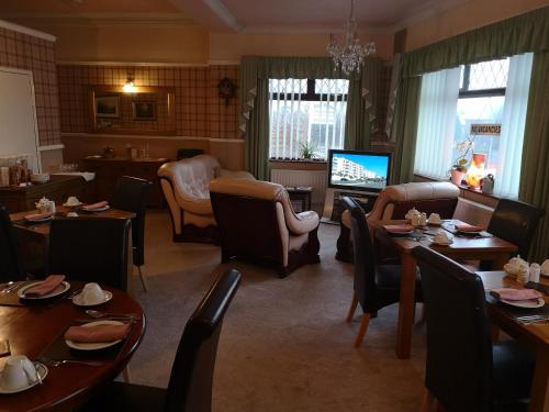 巴罗弗内斯伊斯特茅特酒店的一间带桌椅和电视的用餐室