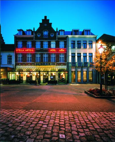 赫伦塔尔斯Hotel De Zalm的一座大建筑,上面有红色 ⁇ 虹灯标志